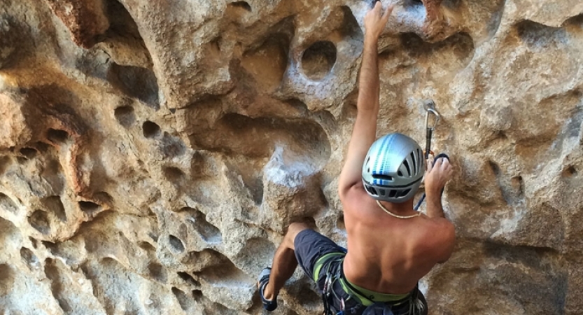 a person wearing safety gear scales a rock wall